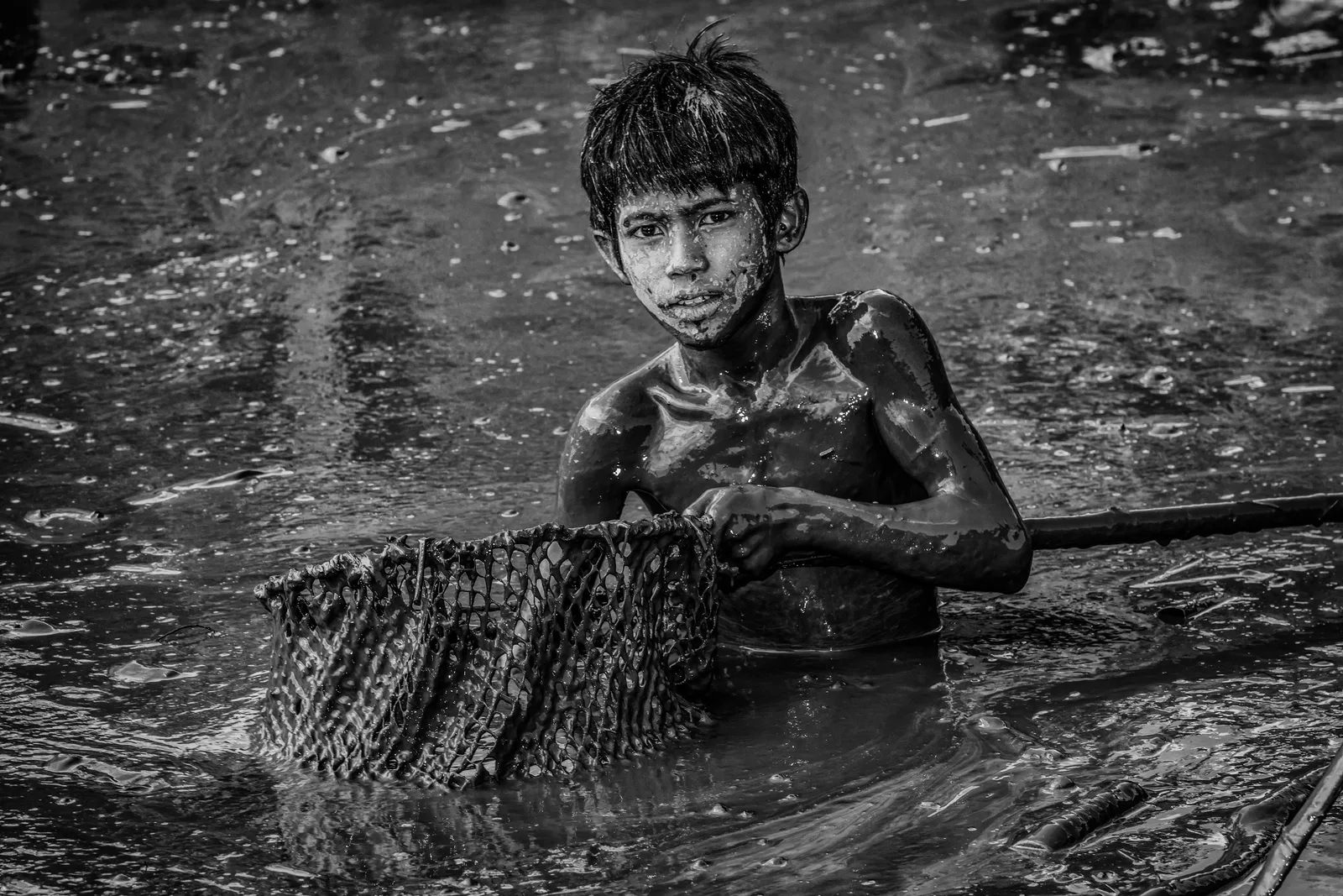 Boy fishing in the mud