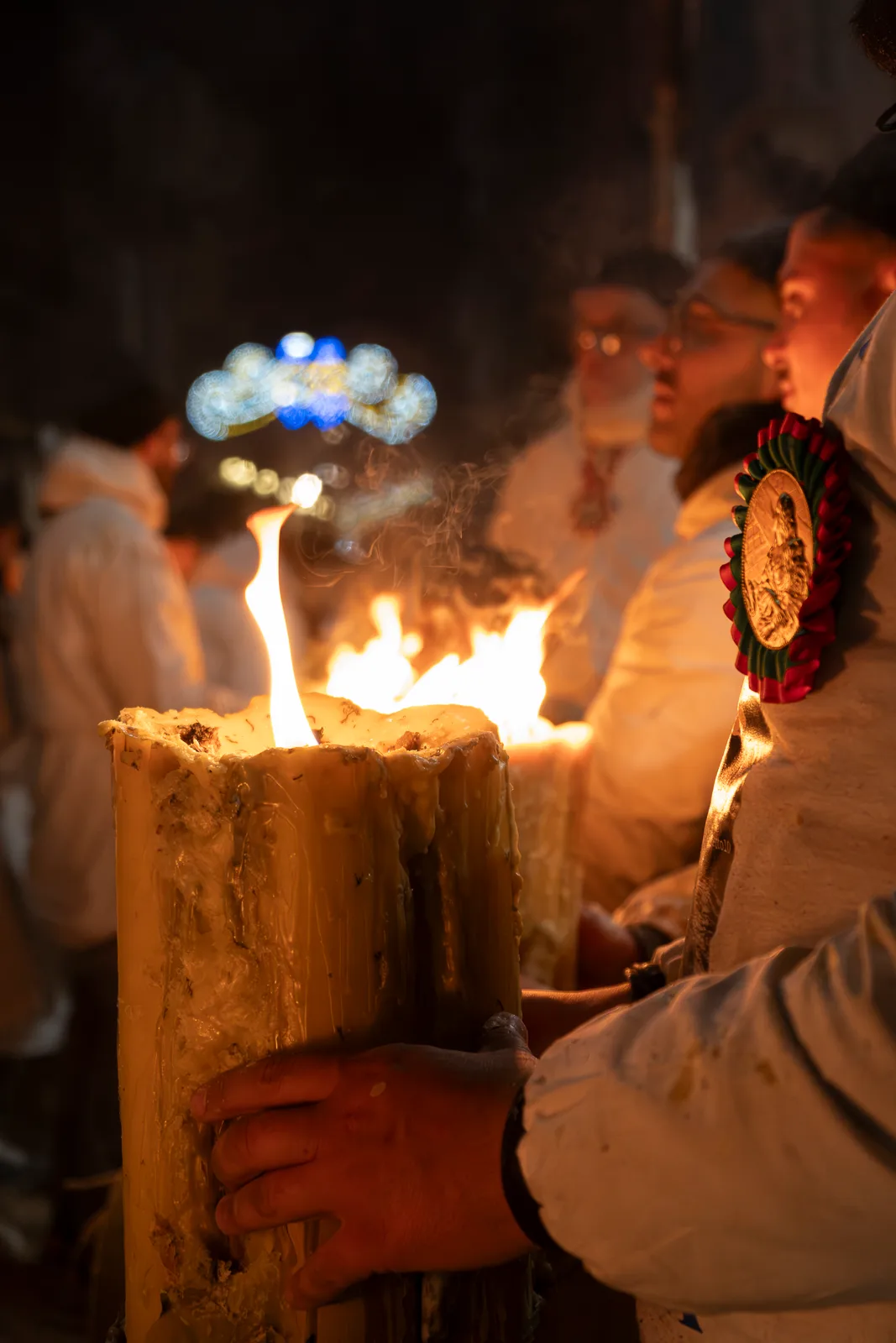 The rosette with the effigy of the Saint is placed over the heart and is part of the dress worn by the “devotees”.